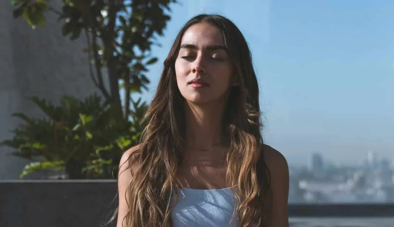 Vrouw mediteert op een dakterras