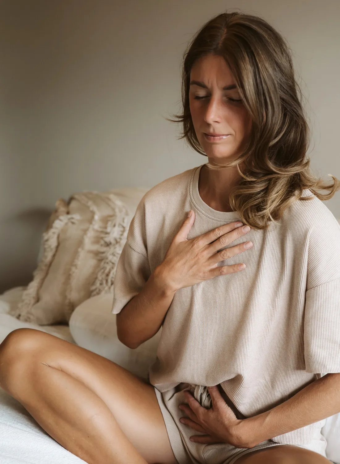 Vrouw zit rustig met haar hand op haar hart